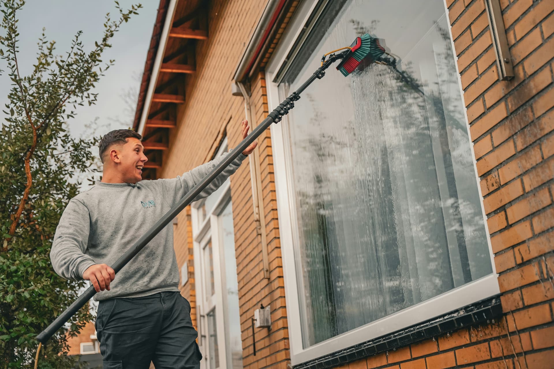 Cleaning a home's exterior window with a water-fed pole